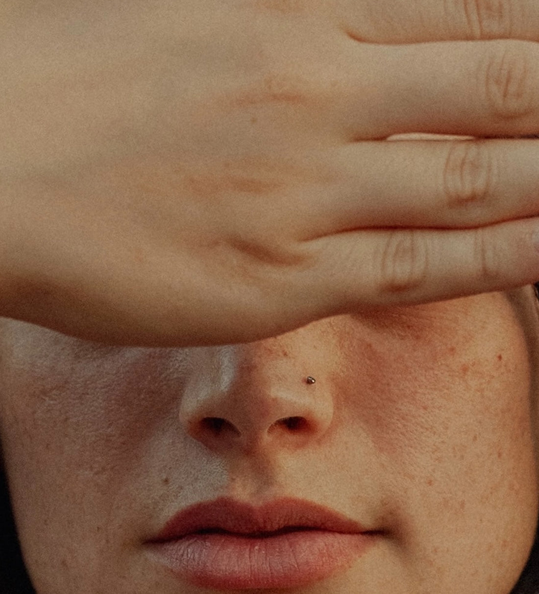 The back of a hand covering the up part of a white womans face