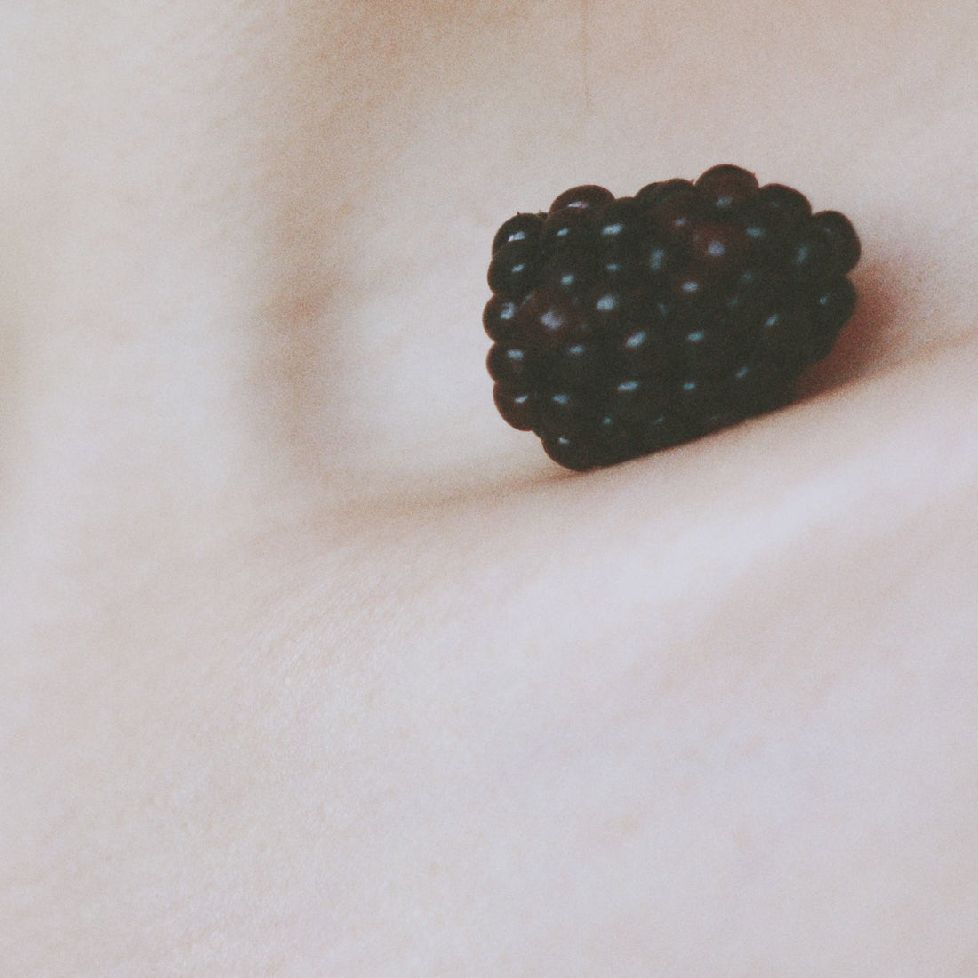 Blackberry nestling in the collarbone of a white person.